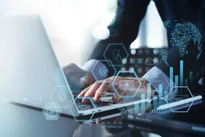 © tippapatt / Adobe Stock Ein Mann arbeitet am Laptop. Symbile for Digitalisierung im Vordergrund.