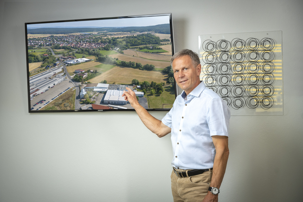 Gerhard Hoffmann vor einem Fotos des Firmensitzes der Hoffmann GmbH Seßlach.